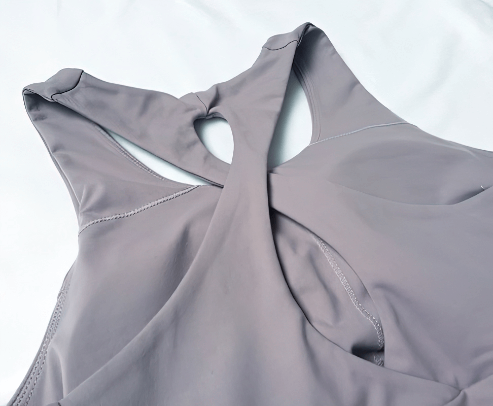 Close-up of sports elastic tight women's cross-back yoga tank in grey, highlighting the stylish cross-back design for optimal airflow.